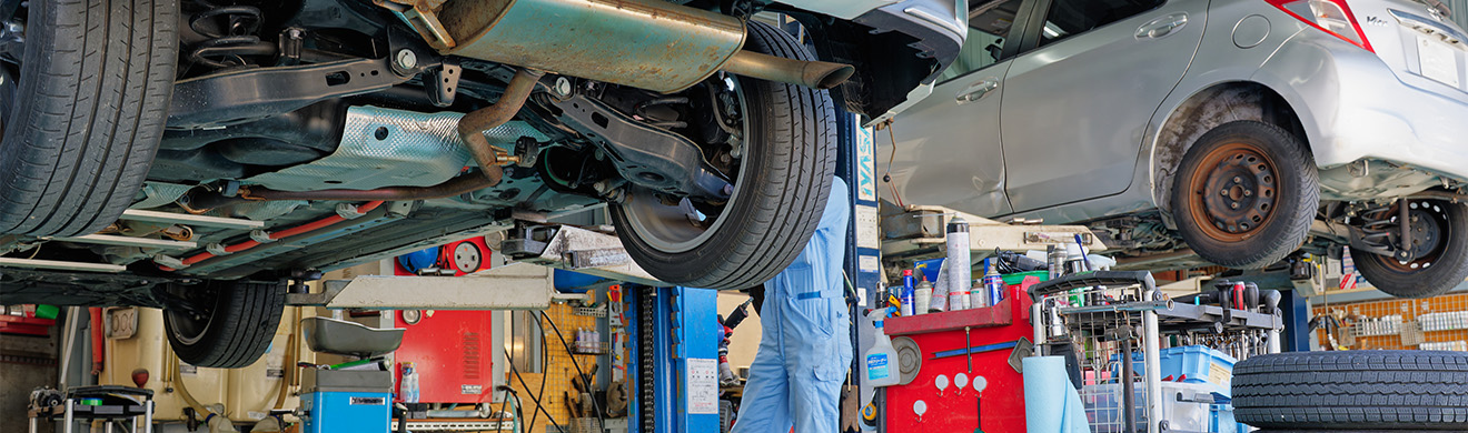 Unterseite eines auf einer Hebeb&uuml;hne angehobenen Pkw in einer Werkstatt f&uuml;r Autoreparaturen in Sinzig