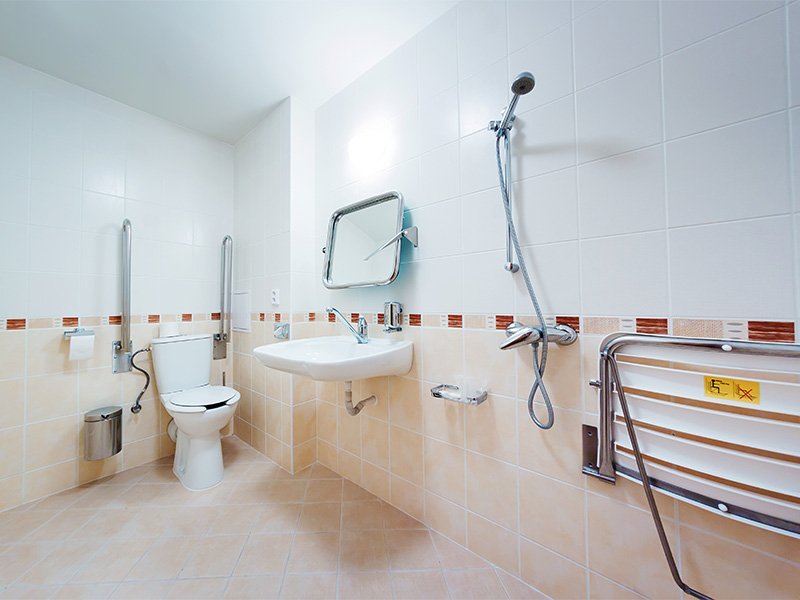 Barrierefreies Badezimmer mit Haltegriffen, ebenerdiger Dusche und rutschfesten Fliesen für sichere barrierefreie Badsanierung.