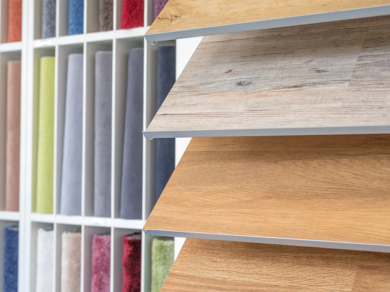 Person wählt Teppich und Laminat aus, um hochwertige Bodenbeläge im Kreis Ahrweiler für Zuhause zu kaufen.