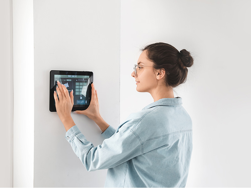 Frau bedient moderne Smart-Home-Steuerung für sichere Elektroarbeiten im Brohltal und intelligente Gebäudetechnik.