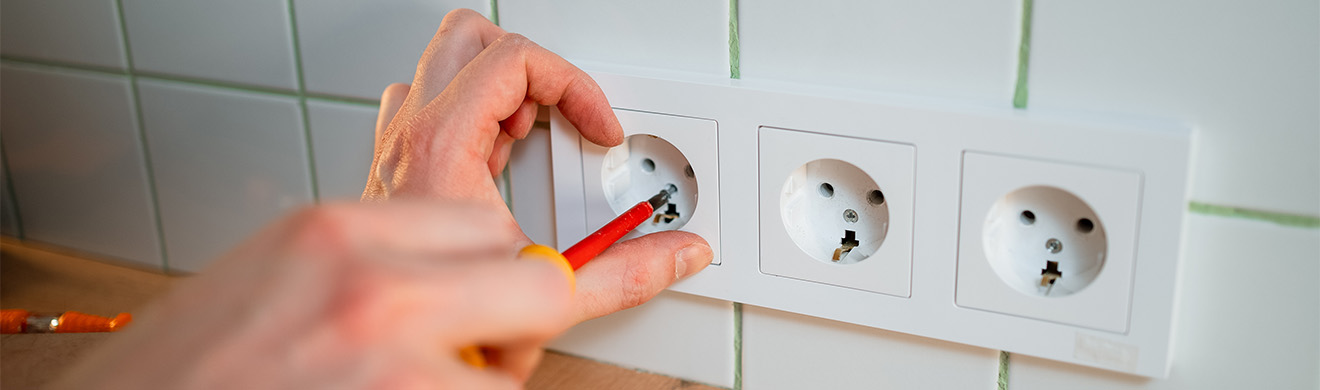 Hand montiert eine Steckdose fachgerecht bei Renovierungsarbeiten und moderner Elektroinstallation.