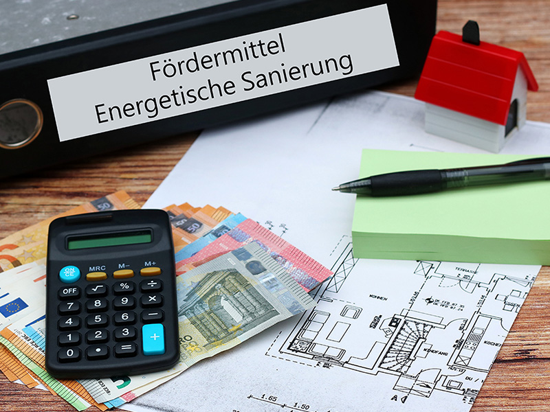 Euro-Geldscheine, Taschenrechner und Bauplan informieren über Fördermittel für eine Dachsanierung in Bad Neuenahr und energetische Modernisierung.