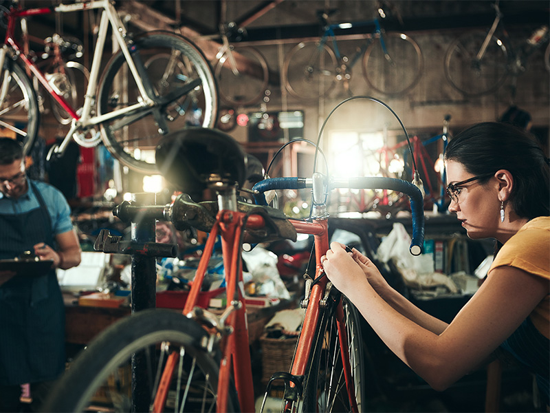 Fahrradmechaniker prüfen und reparieren Fahrräder im Fahrradgeschäft in Bad Neuenahr mit Werkzeug und professionellem Service.