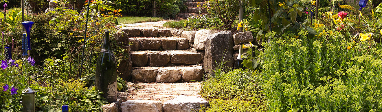 Natursteintreppe mit üppiger Bepflanzung als gestalterisches Element bei der Gartengestaltung in Remagen