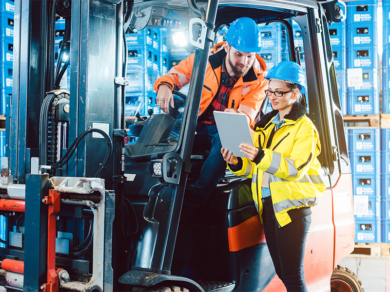 Arbeiter im Logistiklager prüfen den Bestand – zuverlässiger Getränkelieferdienst der Getränke Zimmer GmbH in Adenau.