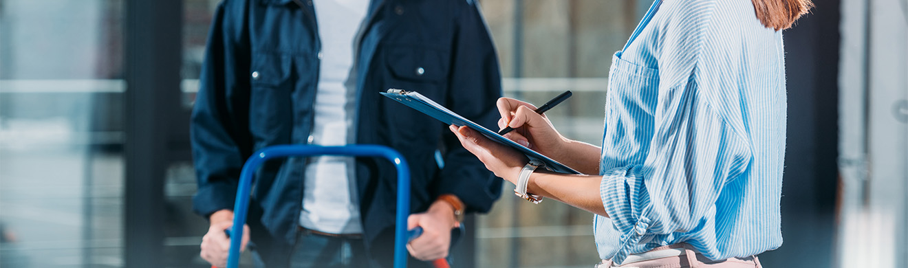 Frau mit Klemmbrett empfängt Wasserlieferung vom Getränkelieferservice – zuverlässiger Getränkeservice im Kreis Ahrweiler.