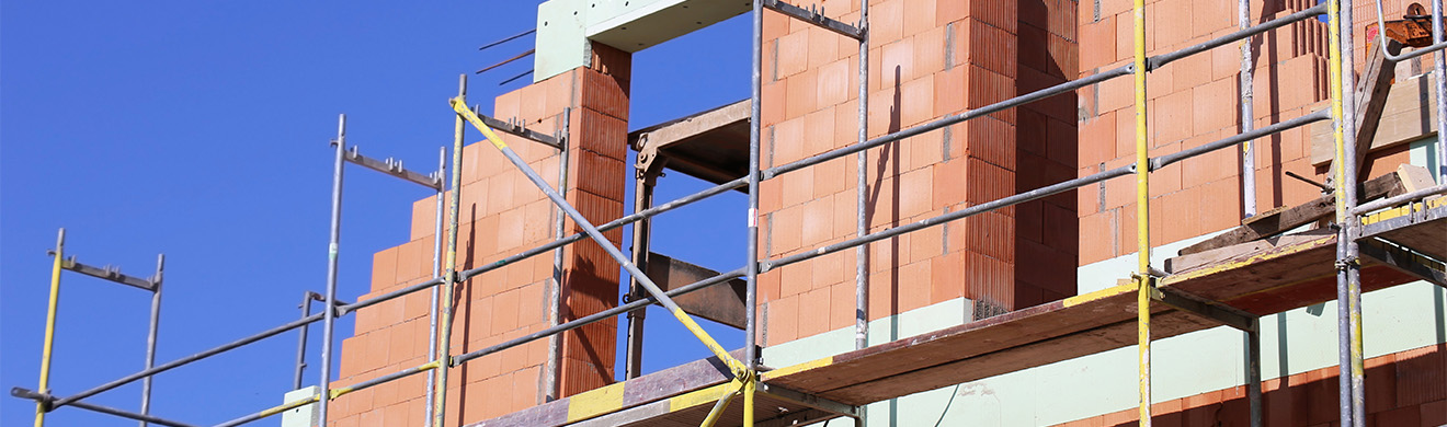 Ein Einfamilienhaus im Rohbau im Kreis Ahrweiler mit sichtbaren Mauerwerks  und Holzrahmenarbeiten im Bauprozess