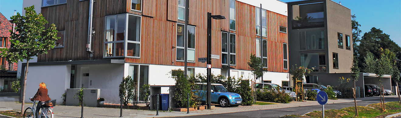 Moderne Wohnanlage mit eleganten Fassaden aus Holz – nachhaltige Architektur mit natürlicher Holzoptik und urbanem Baustil.