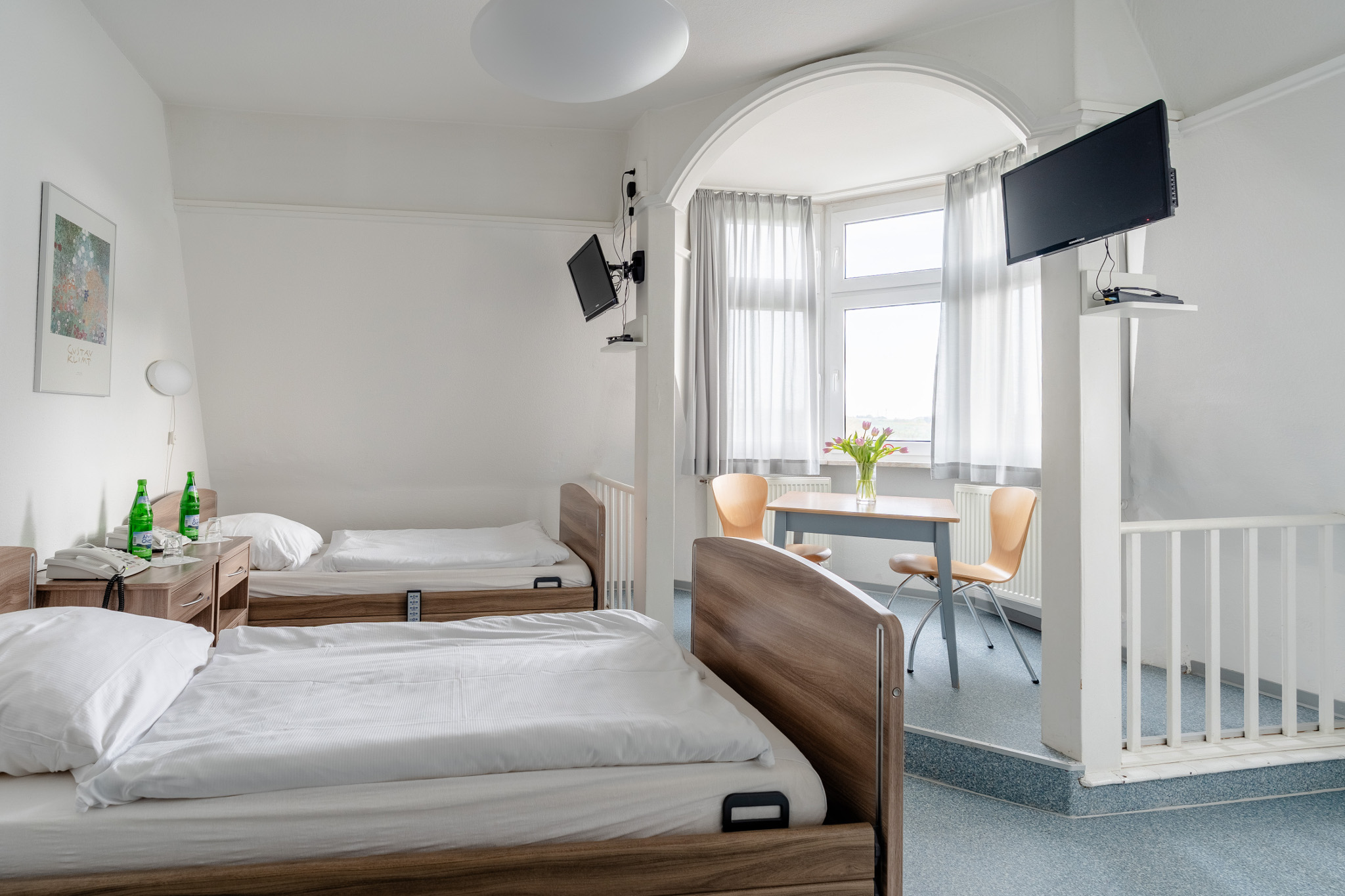 Modernes Patientenzimmer der MVZ VENEN-CLINIC GmbH in Bad Neuenahr-Ahrweiler mit Betten, Sitzbereich und moderner Ausstattung.