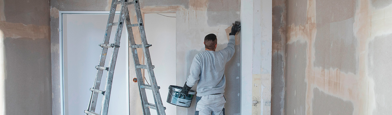 Handwerker glättet eine Wand auf einer Baustelle als Teil der Vorbereitung für Malerarbeiten im Brohltal.