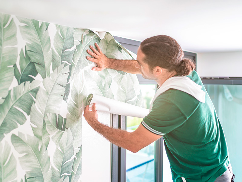 Professioneller Tapezierer bringt eine frische Tapetenbahn an – Innenausstattung im Kreis Ahrweiler modern und stilvoll.