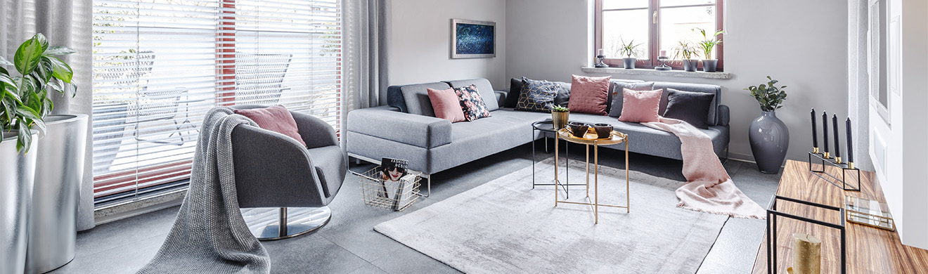 Helles modernes Wohnzimmer mit grauer Einrichtung, gemütlicher Couch und stilvollen Akzenten, gestaltet von Raumausstattern im Kreis Ahrweiler.