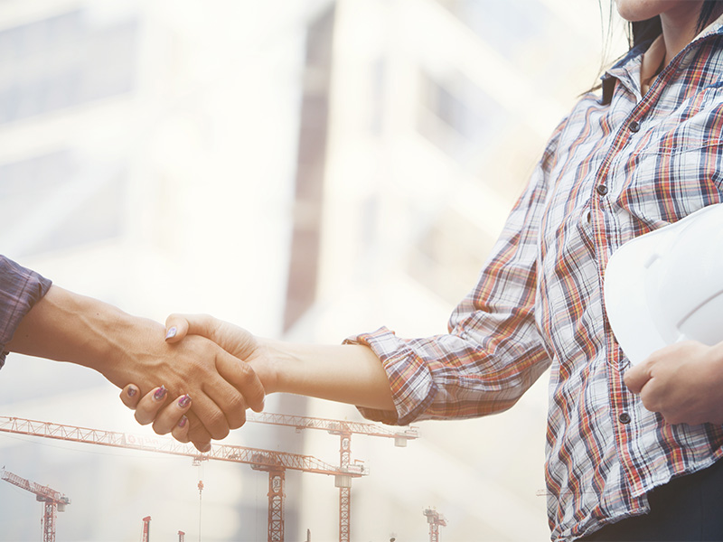 Mediatorin bespricht mit Bauunternehmer auf der Baustelle Lösungen, um einen Baustreit erfolgreich zu schlichten.