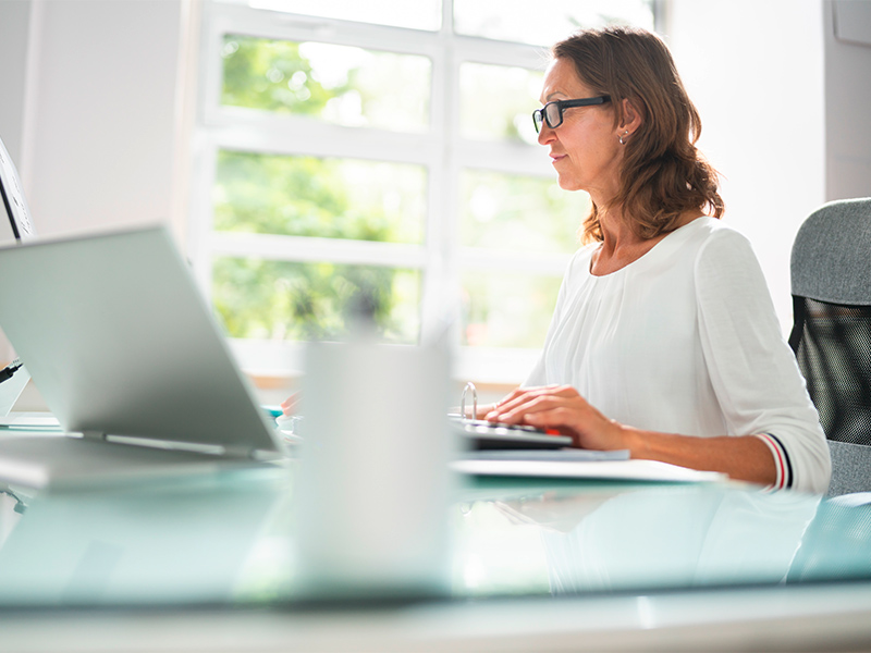 Steuerberaterin arbeitet konzentriert am Laptop im modernen B&uuml;ro und pr&uuml;ft Finanzunterlagen sowie Steuerdaten f&uuml;r Mandanten im Brohltal.